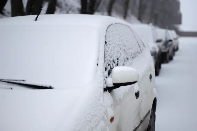 Neve em cima de carros na estrada.